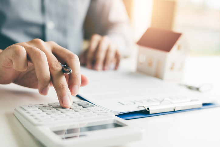 Homeowner using a calculator to calculate the cost of Mortgage Insurance